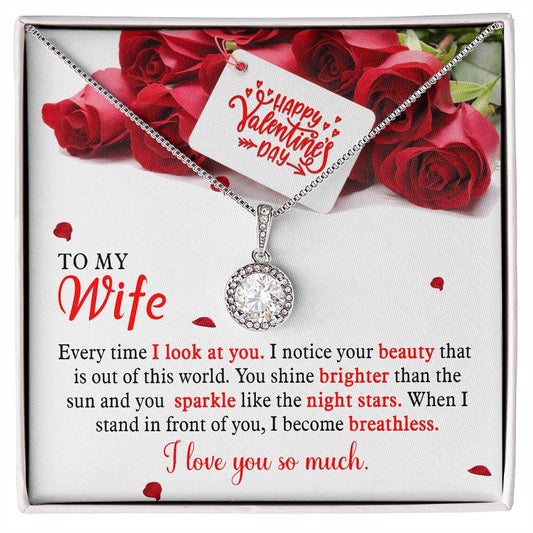 A necklace with a cushion-cut center cubic zirconia surrounded by smaller CZ crystals, displayed in a box with a Valentine's Day message and red roses in the background.